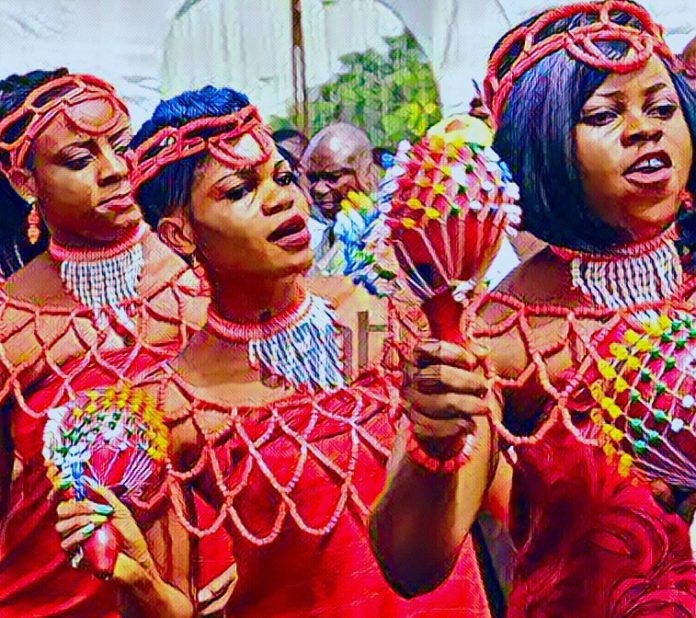 A vibrant Nigerian cultural festival showing dancers in traditional attire during a masquerade celebration.